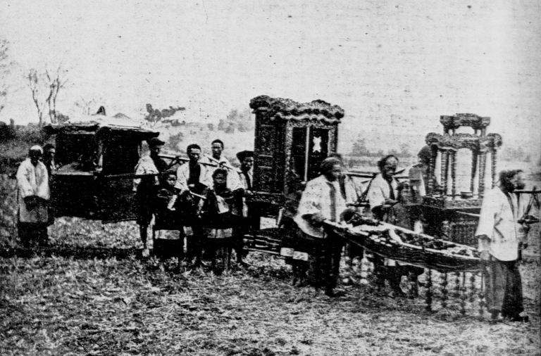 A black and white photo of a traditional funeral march comprised of a group of people carrying musical instruments as well as the corpse.