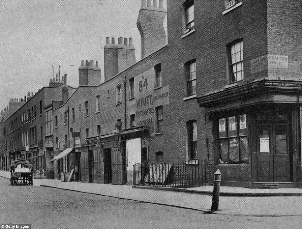 A black and white photo showing an old street with brick buildings