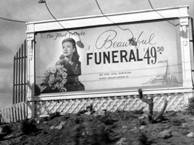 B&W photo of a billboard with a young woman with text reading, 