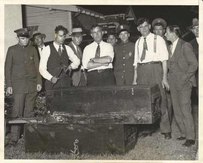 B&W photo of several officials standing behind the casket of Willa Rhoads.