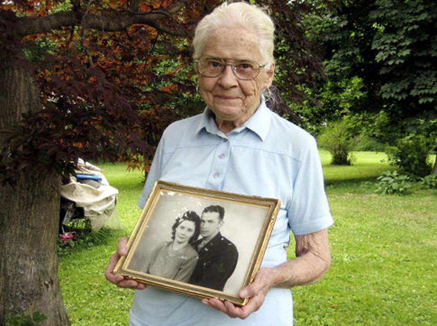 Old lady holding a photograph of a young couple