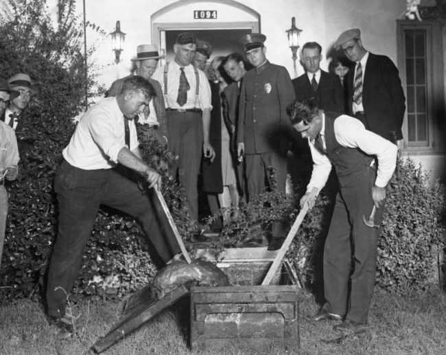 B&W photo of two men looking in the casket of Willa Rhoads, 