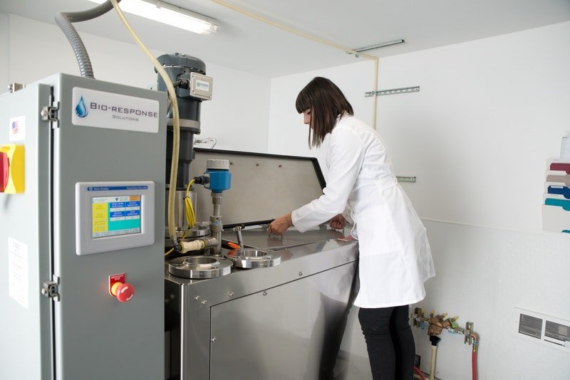 A technician in a white coat prepares an aquamation machine.