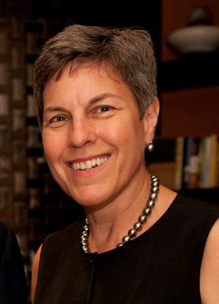 Headshot of woman smiling, wearing black sleeveless top