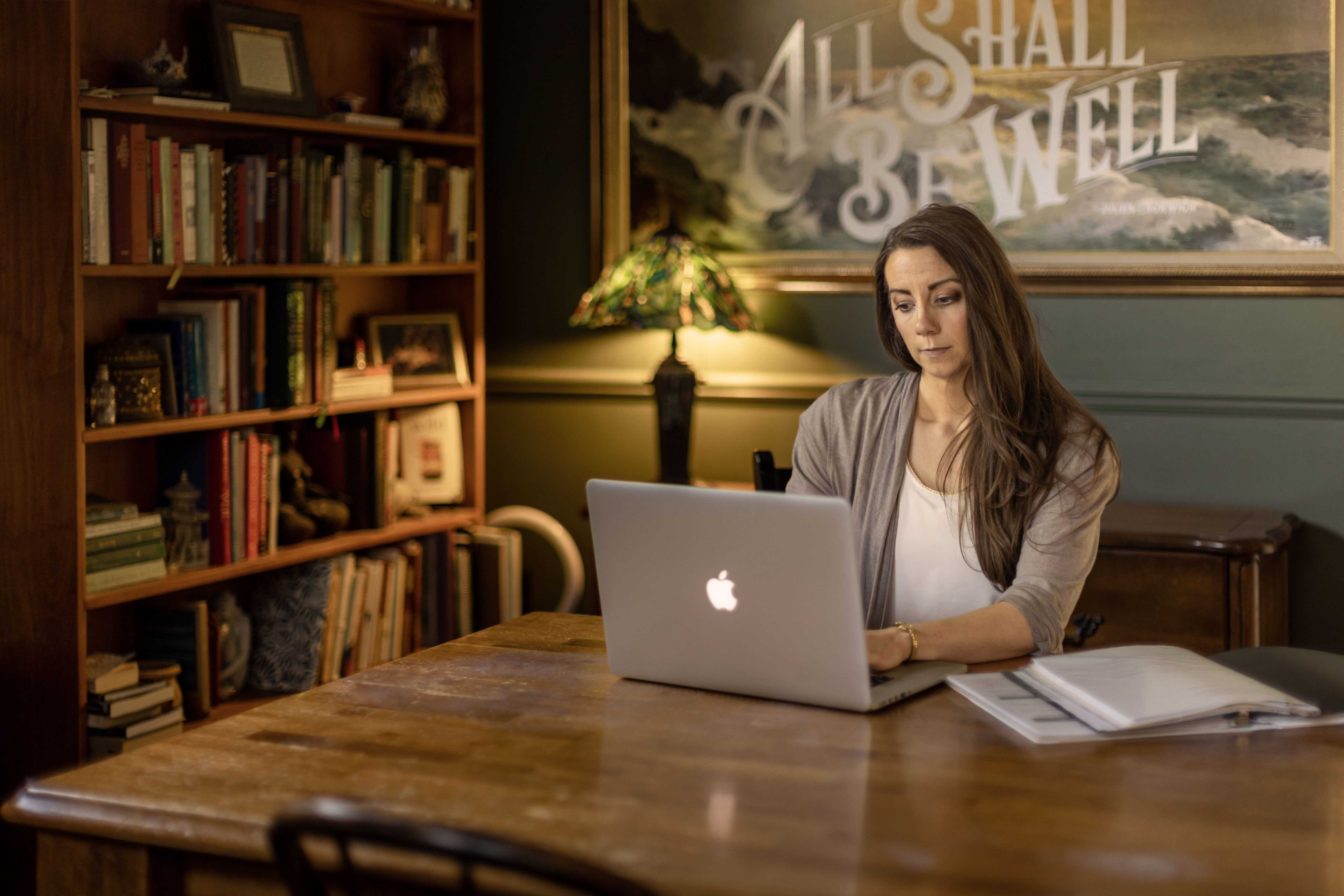 Woman seated at a table working on a laptop