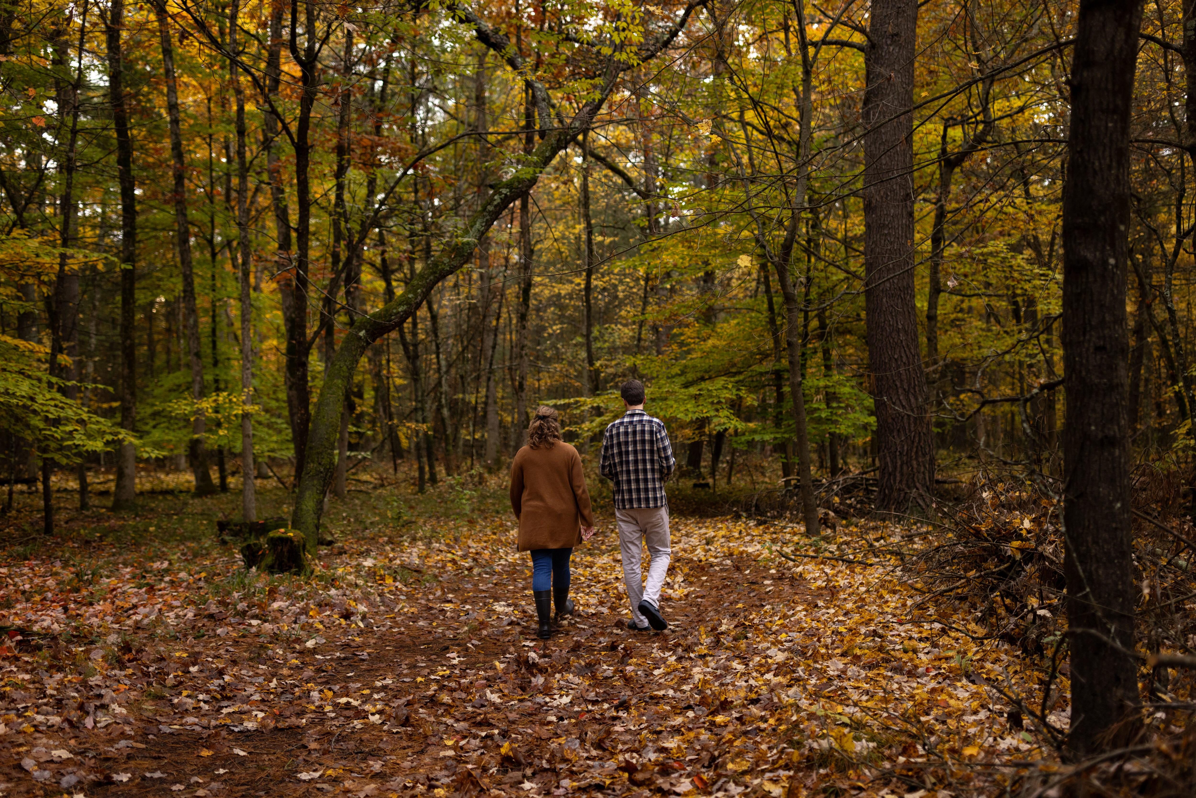 Annica and Peter walking through the burial forest as they hold hands