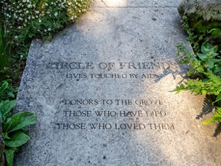 Concrete slab with Inscription at the entrance to the National AIDS Memorial Grove in Golden Gate Park in San Francisco, California. The inscription reads, “Circle of Friends Loves Touched by AIDS / Donors to the Grove / Those Who Have Died / Those Who Loved Them.”