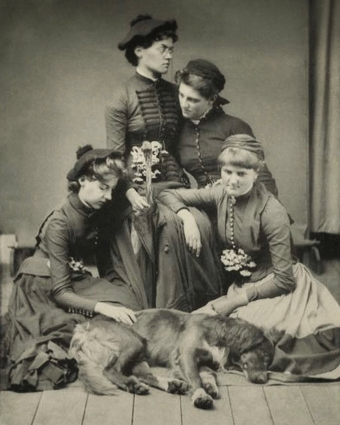 Victorian era tintype photo of womne, dressed in mourning gathered around the body of a beloved dog