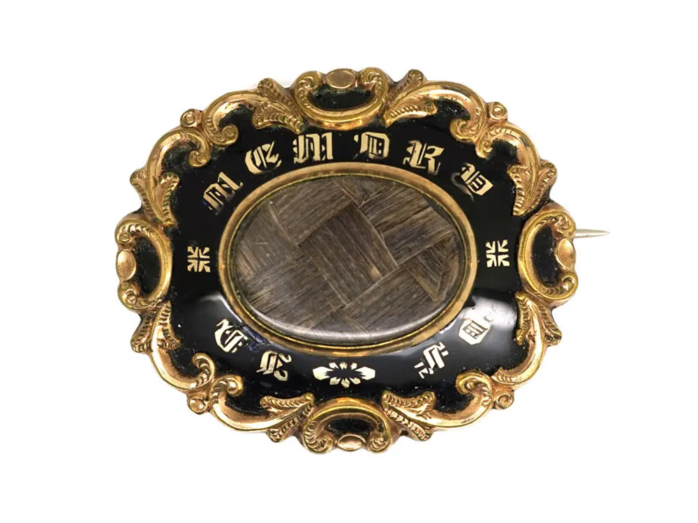 Photo of a Victorian mourning brooch that has hair encased in it